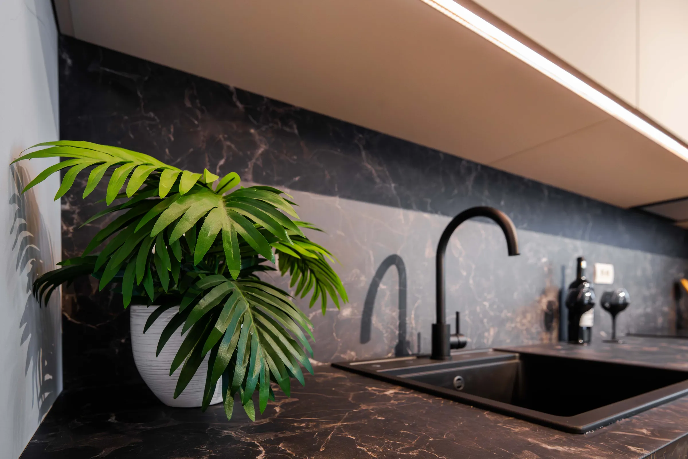 Detaliu bucătărie cu robinet negru, showroom 2 camere